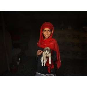 Girl Holds a Puppy as the Sun Sets over Kabuls Impoverished Teppe 